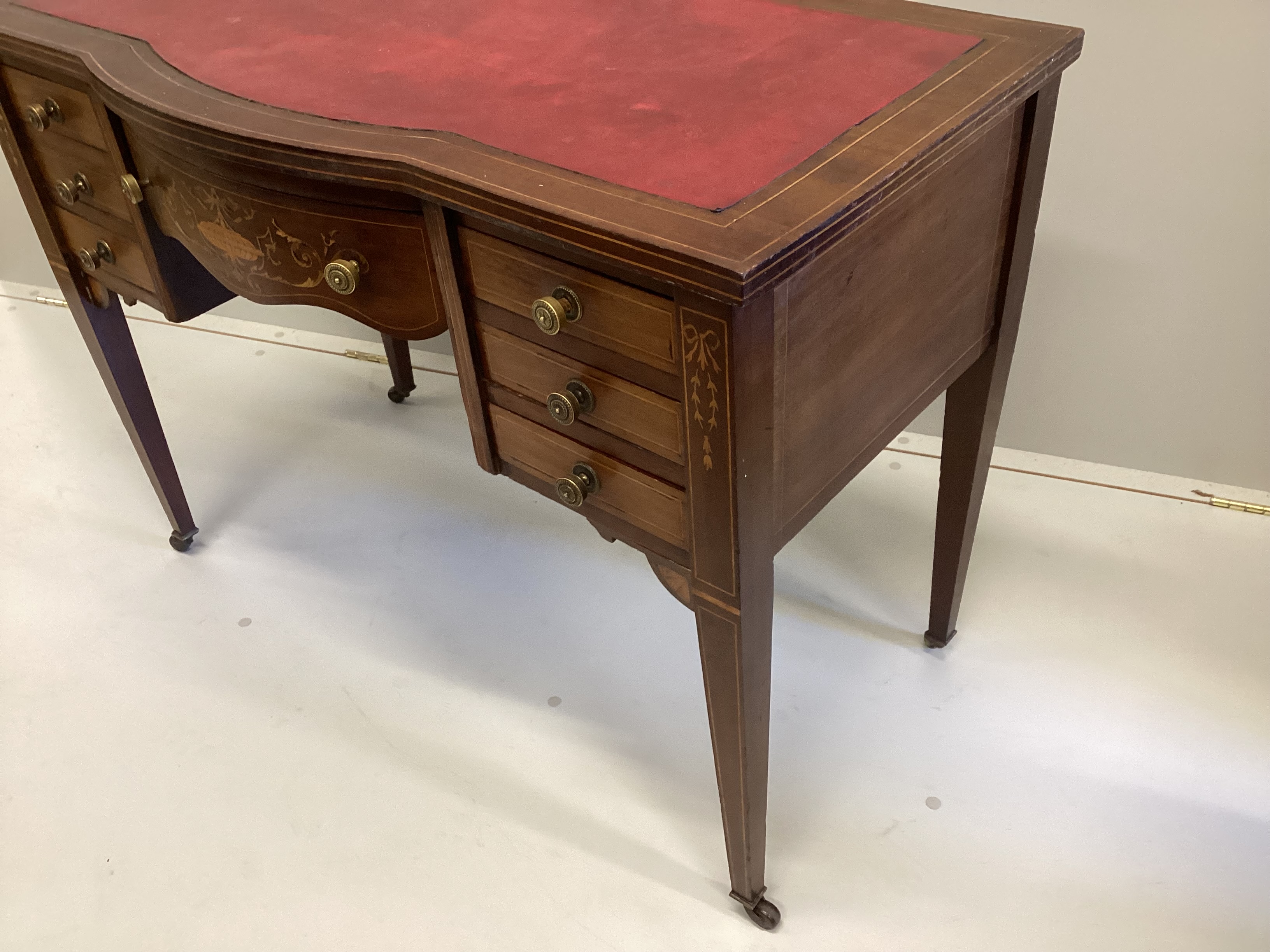 An Edwardian inlaid mahogany bowfront kneehole writing table, width 99cm, depth 52cm, height 73cm
